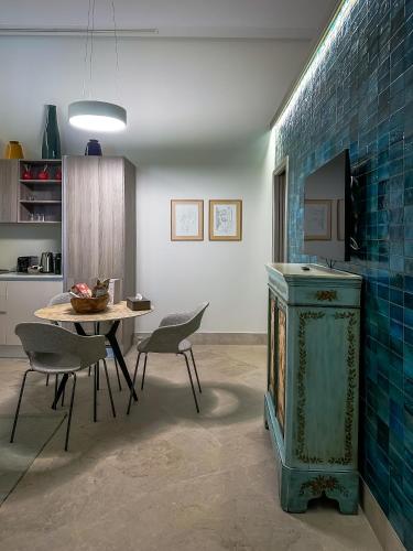 a kitchen with a table and a blue tiled wall at Dar Ben Turkia in Tunis