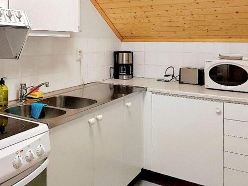a white kitchen with a sink and a microwave at 5 person holiday home in LAMMHULT, SVERIGE in Förhult