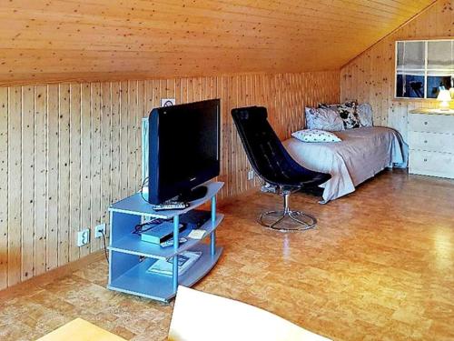 a bedroom with a bed and a tv and a chair at 5 person holiday home in LAMMHULT, SVERIGE in Förhult