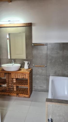 a bathroom with a sink and a mirror and a tub at Quinta dos Milagres Chafariz 38 in Friumes