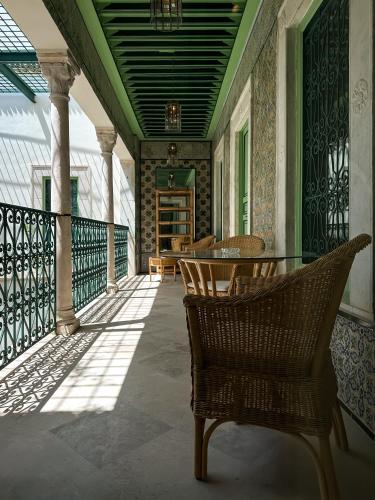 a balcony with chairs and a table on a house at Dar Ben Turkia in Tunis