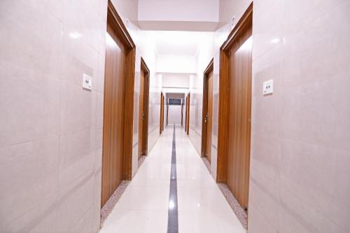 a corridor of an office building with white floors and wooden walls at Hotel O Shree Raghuvar Dham in Vrindāvan