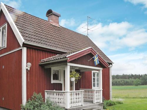 a red house with a white porch and a roof at 4 person holiday home in GULLSPÅNG-By Traum in Tattertorp