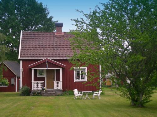 a red house with a table and chairs in the yard at 4 person holiday home in GULLSPÅNG-By Traum in Tattertorp