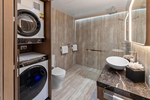 a bathroom with a washer and a washing machine at Distinction Invercargill Hotel in Invercargill