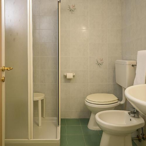 a bathroom with a toilet and a sink and a shower at Hotel Villa Maria in Caorle