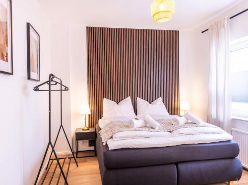 クレーフェルトにあるNUIT Apartment - HBF, Zentral, Helios-Klinik, Messe Düsseldorf 20 Min, NEUの黒と白のヘッドボードが付いたベッドのある寝室