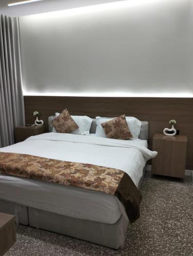 a bedroom with a large bed with white sheets and pillows at شقق مساكن السمو المخدومة in Ad Dawādimī