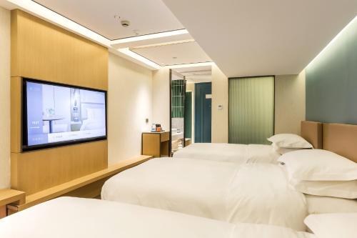 Ένα ή περισσότερα κρεβάτια σε δωμάτιο στο JinglaiHotel Bushe Shanghai Bund Branch