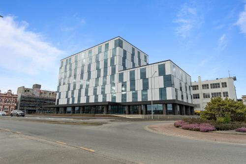 a large glass building on the corner of a street at Distinction Invercargill Hotel in Invercargill