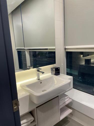 a white bathroom with a sink and a window at Suasana Suites Johor Bahru City Centre in Johor Bahru