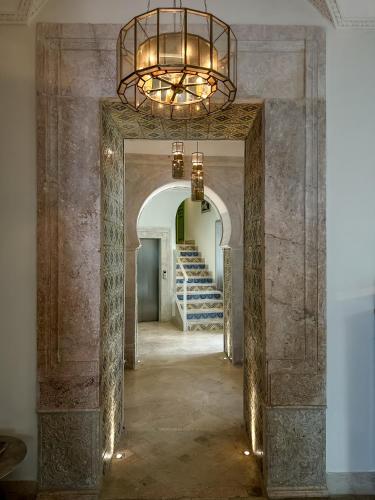 a hallway with a chandelier and stairs in a building at Dar Ben Turkia in Tunis