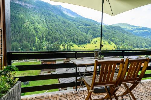 a table and chairs on a balcony with a view of mountains at Résidence Dent-Blanche, Evolène in Evolène
