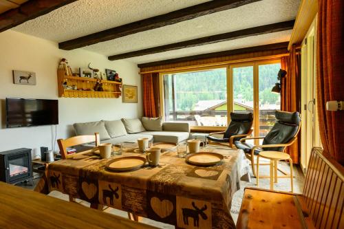 a living room with a table and chairs and a couch at Résidence Dent-Blanche, Evolène in Evolène