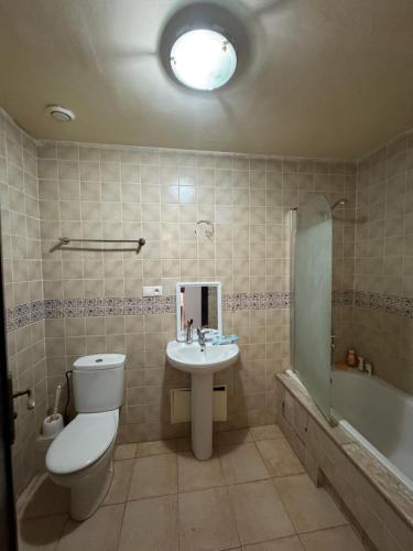 a bathroom with a toilet and a sink and a tub at Luxueuse à Marina Saidia in Saïdia