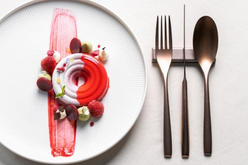 a white plate with a dessert with strawberries on it at Hotel Nani Mocenigo Palace in Venice