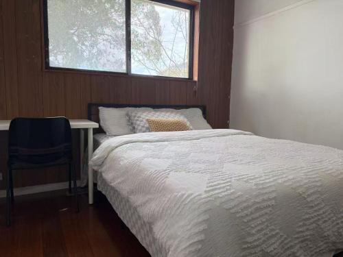 Una cama o camas en una habitación de Happy Post-Glen Waverley