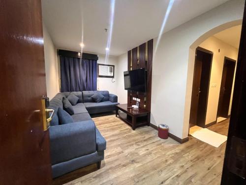 a living room with a couch and a television at Makarim Palm Hotel in Rabigh