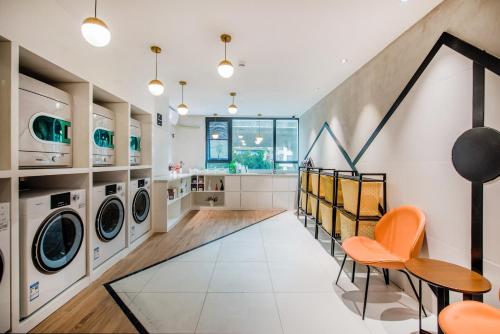 a laundry room with washing machines and a table and chairs at Atour Hotel Guangzhou Sanyuanli-Guangzhou Baiyun Railway-Fiee Self-Service Laundry in Guangzhou