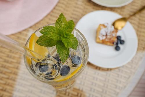 a glass of drink with blueberries and mint on a table at Hotel Pfeifer in Gaschurn