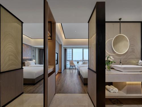 a hotel room with a bathroom and a bedroom at 上海野生动物园荷逸唐酒店-惠南地铁站店 in Nanhui