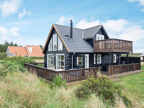 een zwart huis met een terras op een veld bij 5 person holiday home in Skagen-By Traum in Kandestederne