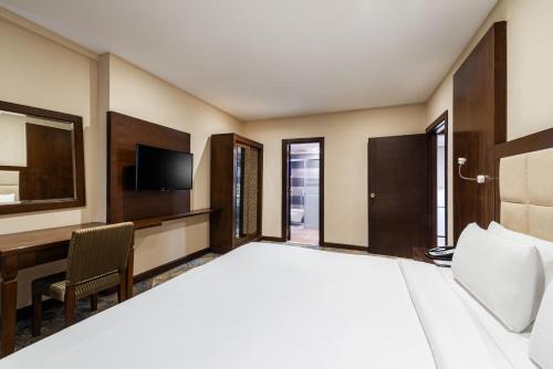 a hotel room with a large bed and a desk at Razana Al Rawdha Hotel in Makkah