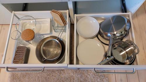 eine Schublade mit Töpfen, Pfannen und anderen Küchenutensilien in der Unterkunft Grandma's cottage in Sotkamo