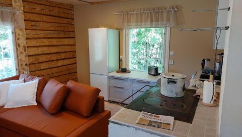 eine Küche mit einem Sofa und einem Herd in einer Küche in der Unterkunft Grandma's cottage in Sotkamo