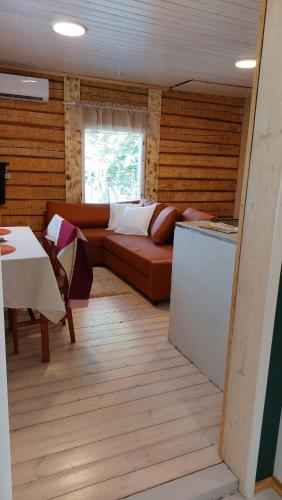 a living room with a couch and a table at Grandma's cottage in Sotkamo