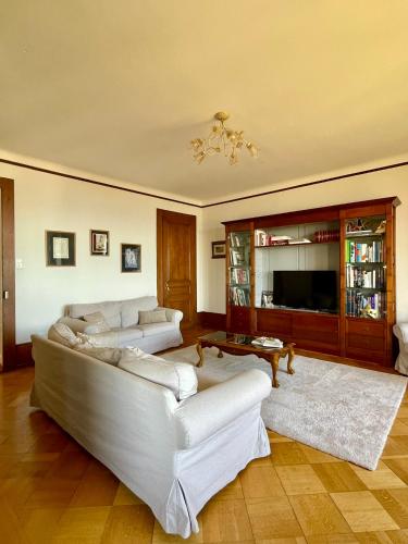 a living room with two white couches and a television at Bellavista in Neuchâtel