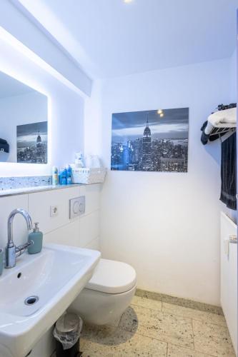 a bathroom with a white toilet and a sink at Rob's Place - Ruhige 2-Zi-City-Oase mit Panorama über den Weberplatz in Essen
