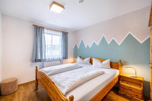a bedroom with a large bed with a blue accent wall at Fewo Brünnstein - Nr 27 Pool, Sauna in Oberaudorf