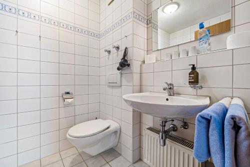 a white bathroom with a sink and a toilet at Fewo Brünnstein - Nr 5 Pool, Sauna in Oberaudorf