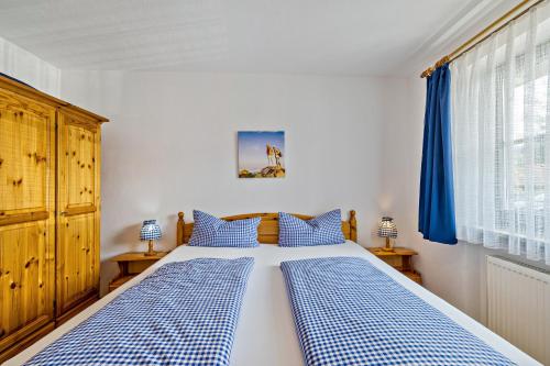 a bedroom with a bed with blue and white checked pillows at Fewo Brünnstein - Nr 5 Pool, Sauna in Oberaudorf