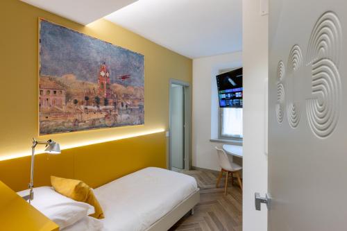 a room with a bed and a painting on the wall at Albergo Ristorante Corsini in Pavullo nel Frignano