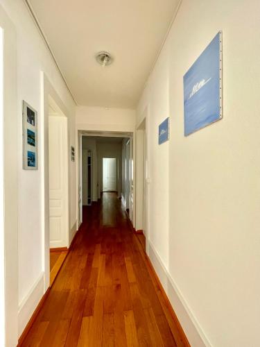 an empty hallway with wood floors and paintings on the walls at Bellavista in Neuchâtel