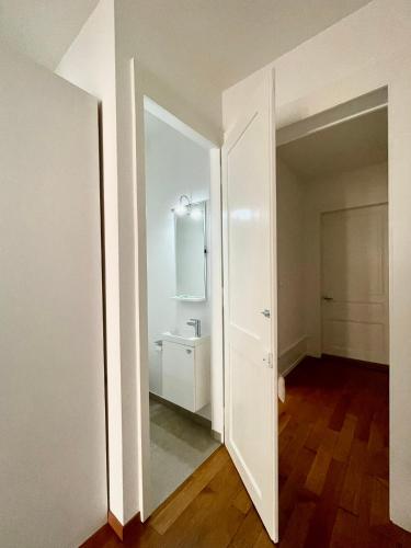 an empty white bathroom with a sink and a mirror at Bellavista in Neuchâtel