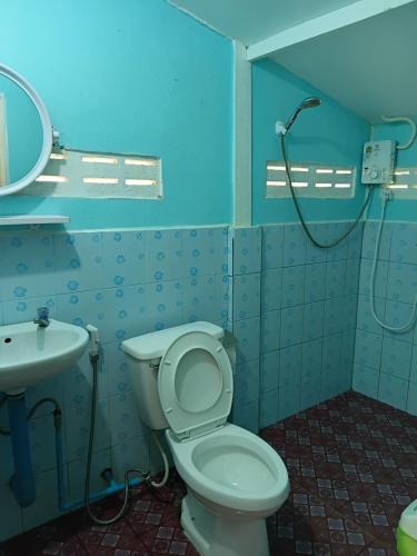 a blue bathroom with a toilet and a shower at Cha Bungalow in Ko Yao Noi