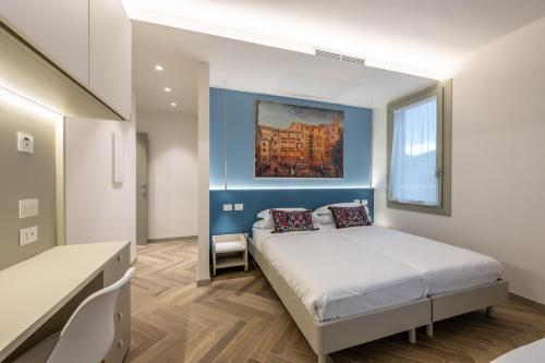 a bedroom with a bed and a painting on the wall at Albergo Ristorante Corsini in Pavullo nel Frignano