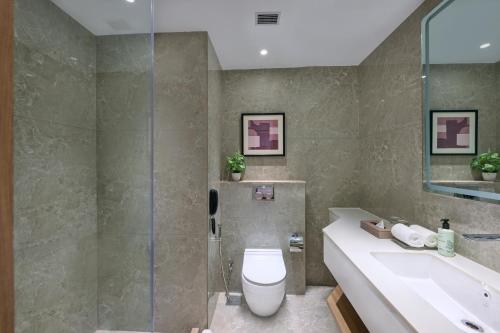 a bathroom with a toilet and a sink at Riviera Sarovar Portico Pathankot in Pathānkot