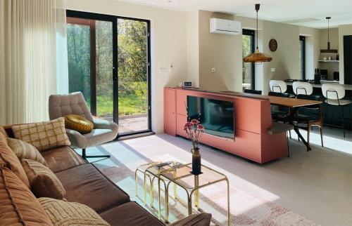 a living room with a couch and a tv and a table at Vakantiegeluk in Zorgvlied