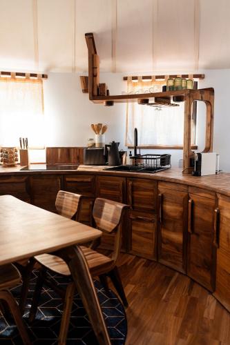 a kitchen with wooden cabinets and a table and chairs at Farkaskútvölgy in Felsőtold