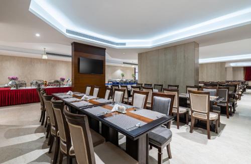 a conference room with a long table and chairs at Razana Al Rawdha Hotel in Makkah