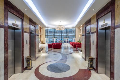 a lobby with red couches and a chandelier at Razana Al Rawdha Hotel in Makkah