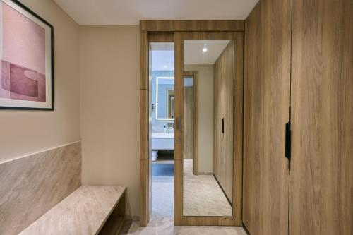a hallway with a wooden door and a mirror at Riviera Sarovar Portico Pathankot in Pathānkot