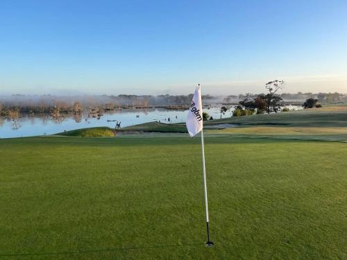 a golf course with a flag on a green at Longford Cottage in Longford