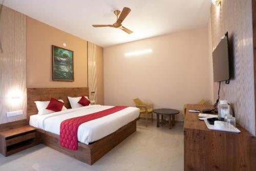 a hotel room with a bed and a flat screen tv at MSB Silver Spring Resort in Yelagiri
