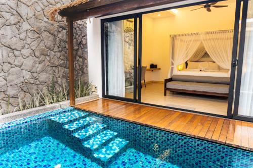 a pool in a room with a bed in the background at La Villa Langkawi - Private Pool in Pantai Cenang