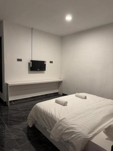 a bedroom with a bed and a tv on the wall at Pandan Hotel in Papar